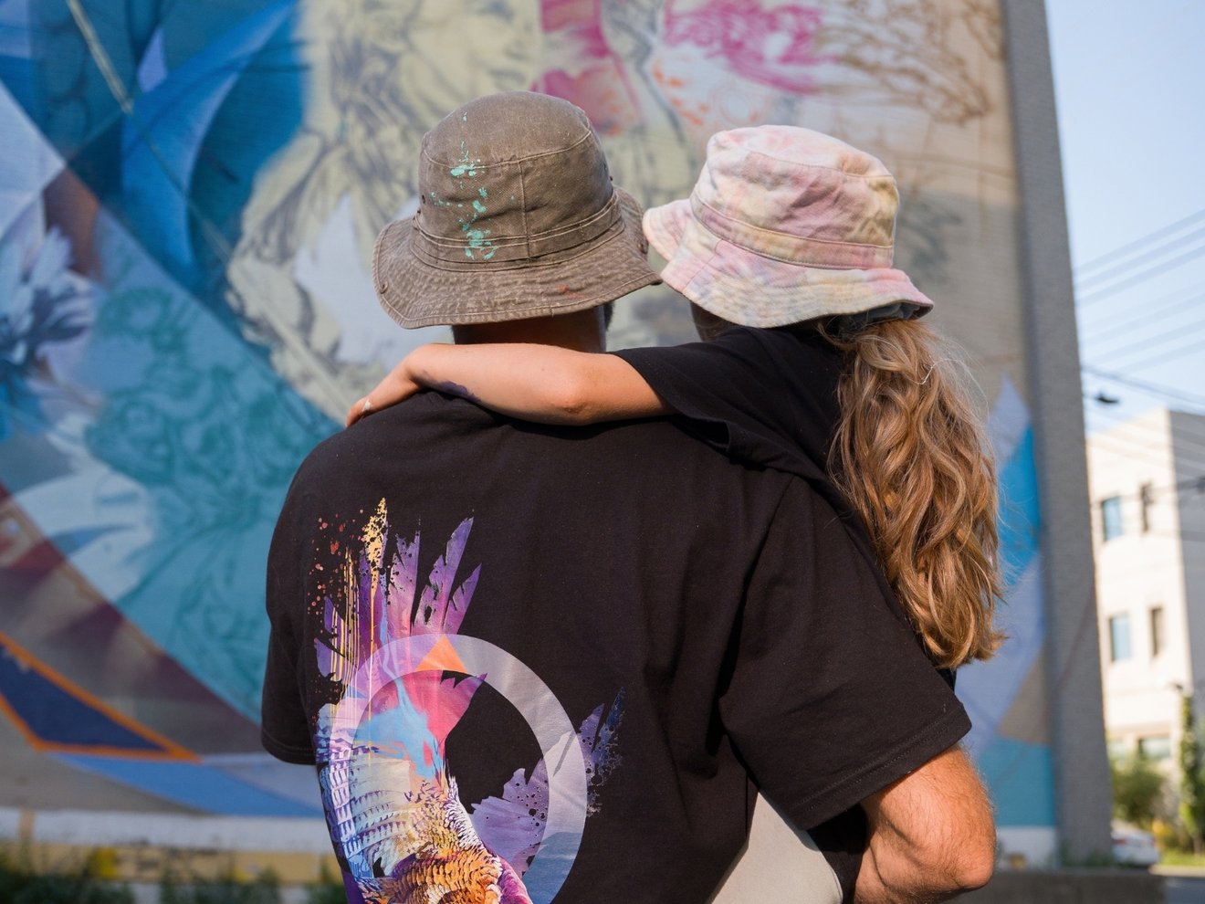 Fluke holding Amaya in front of mural