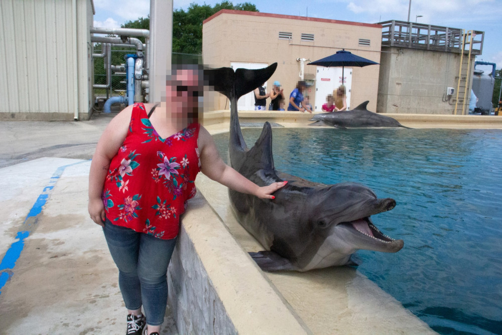 Tourist posing with dolphin at cruel wildlife attraction - World Animal Protection - Wildlife. Not entertainers